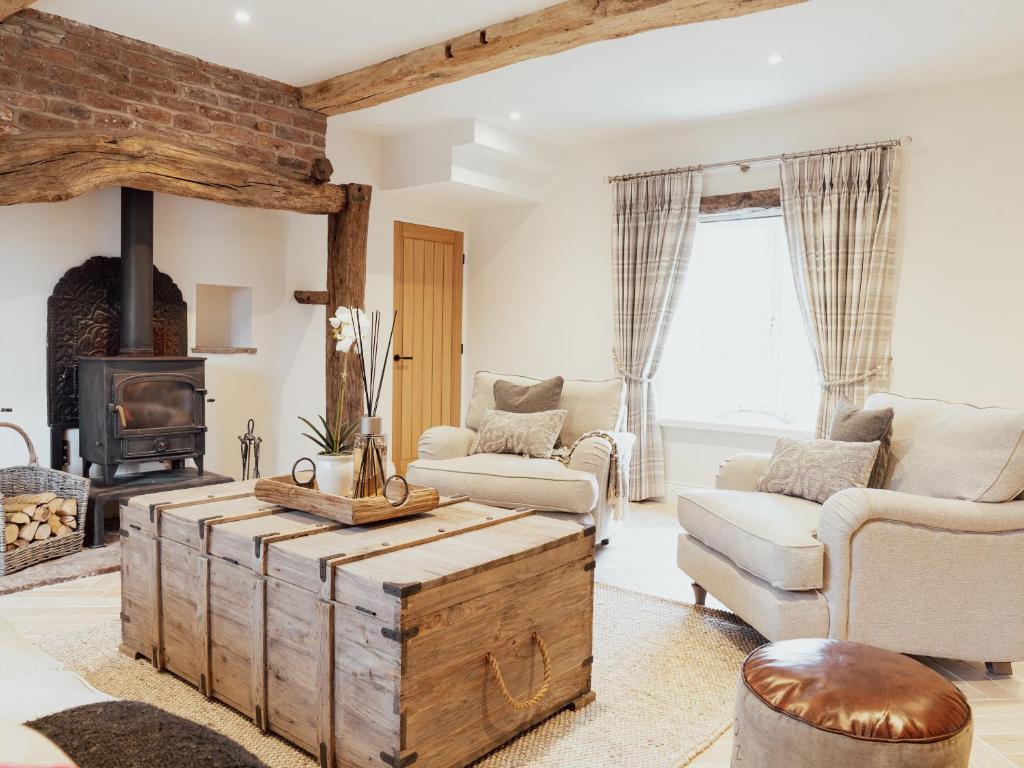a living room with a wooden coffee table and a fireplace at Stag Cottage in Macclesfield