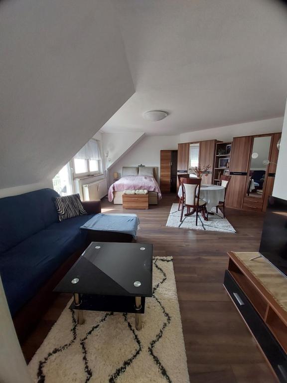 uma sala de estar com um sofá azul e um quarto em StayInn Möckern - 1 Zimmer Apartment für 3 Personen em Leipzig