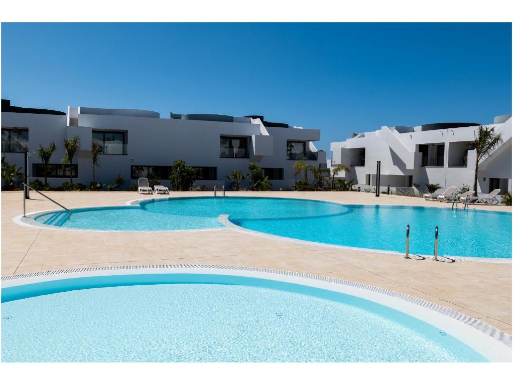 a large swimming pool in front of a building at Casa Tiare in La Oliva