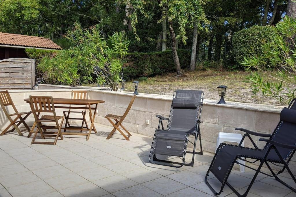 d'une terrasse avec des chaises, une table en bois et des chaises. dans l'établissement village Khelus, à Gujan-Mestras