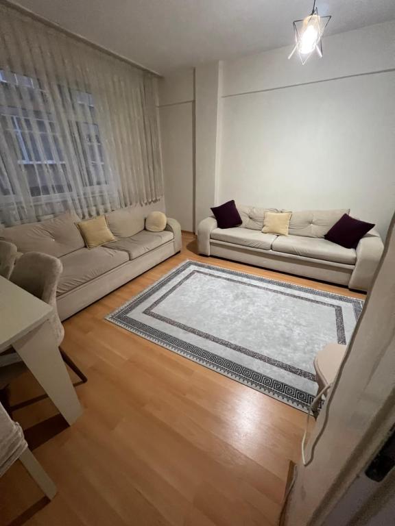 una sala de estar con 2 sofás y una alfombra grande en Müslüm en Estambul