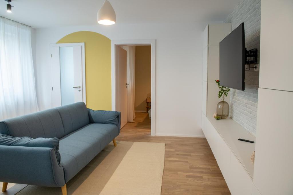 un soggiorno con divano blu e TV di Andor apartment near park and subway a Bucarest
