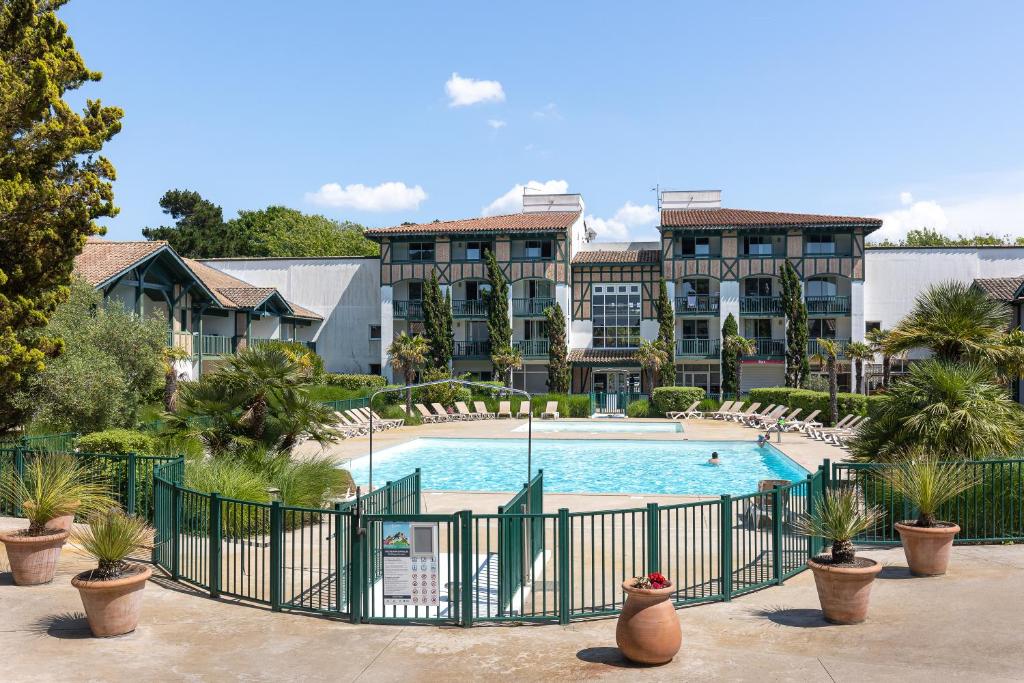 une vue d'une piscine dans un complexe hôtelier dans l'établissement L'orée, à Moliets-et-Maa