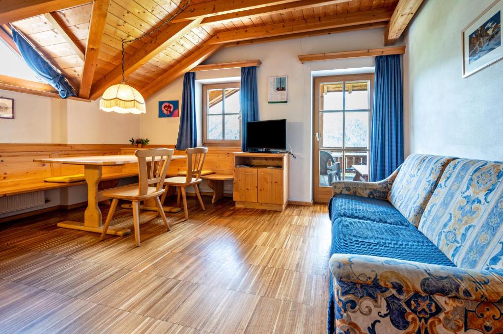 un soggiorno con un divano e un tavolo da pranzo di Lindenhof Apt 1 a Vandoies
