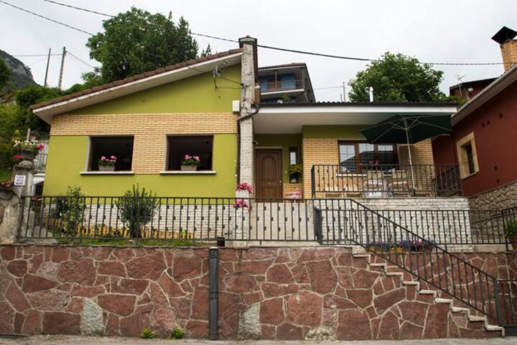 una casa amarilla con una valla y una pared de piedra en Casa La Bolera, en Carreña