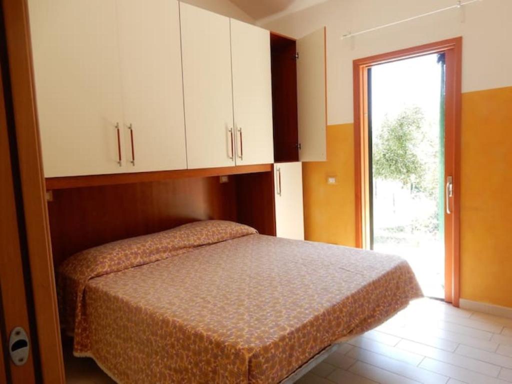 una camera da letto con un letto con armadi bianchi e una finestra di Casa Ventitre a Campo nell'Elba