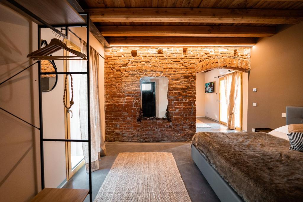 Habitación con cama y pared de ladrillo en Bed & Breakfast Gioia di..., en Santo Stino di Livenza