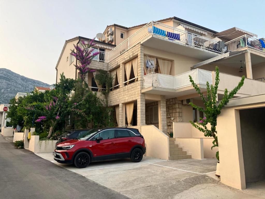 a red car parked in front of a building at Apartmani Fani 2 min walking from sea in Orebić