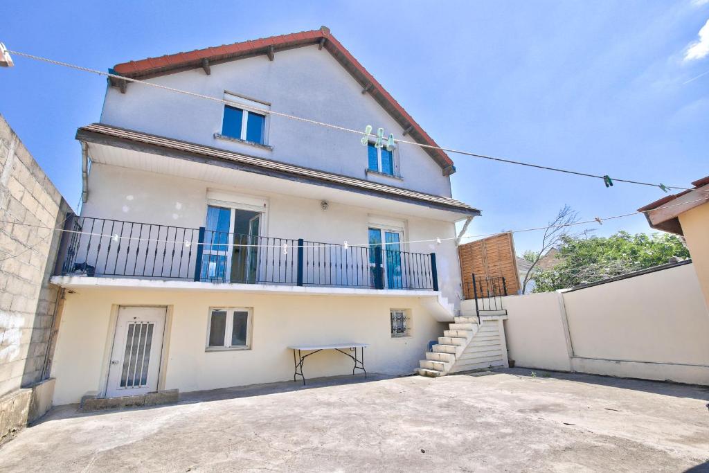 a large white house with a balcony at Appartement meublé Dugny in Dugny