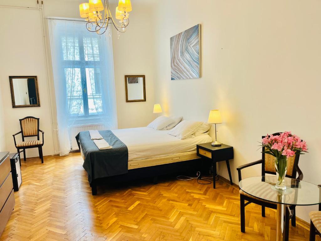 1 dormitorio con 1 cama y 1 mesa con flores en City Rooms, en Budapest