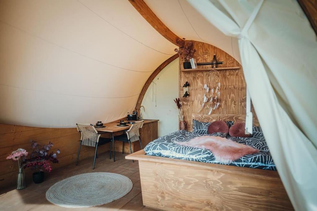 Zimmer mit einem Bett und einem Tisch in einem Zelt in der Unterkunft WOW magisches Luxus Glamping mit Pool im Paradies in Bad Salzdetfurth