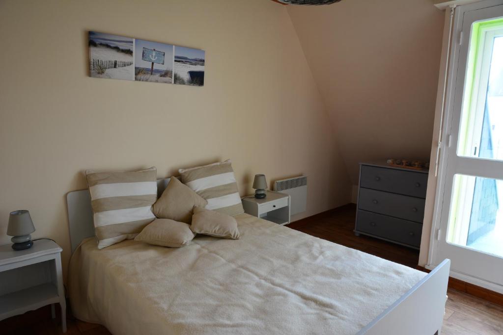 une chambre avec un grand lit blanc avec deux oreillers dans l'établissement Maison près des plages, à Tréffiagat