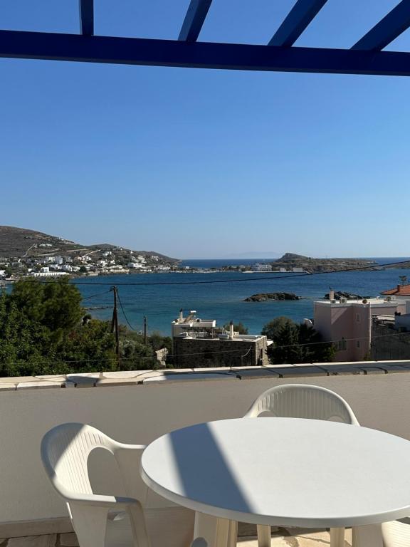 a table and chairs on a balcony with a view of the water at Molly’s Home in Víssa