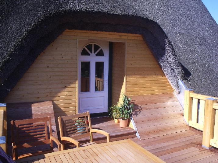 ein kleines Haus mit einer Tür und zwei Stühlen auf einer Terrasse in der Unterkunft Ferienwohnung Mattke in Heiligendamm