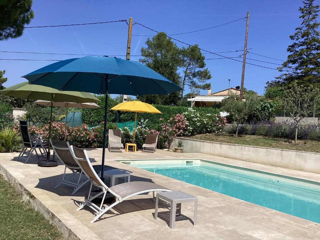 a patio with chairs and an umbrella next to a pool at Mas Madilauric 2 BNB in Peymeinade