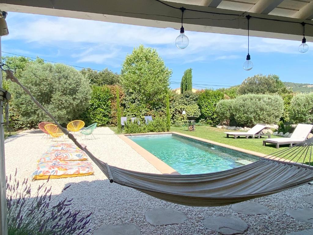 a hammock in front of a swimming pool at villa Luberon in Saint-Saturnin-dʼApt