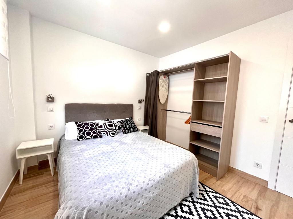 Dormitorio blanco con cama y armario en Maximilian 3, en Madrid