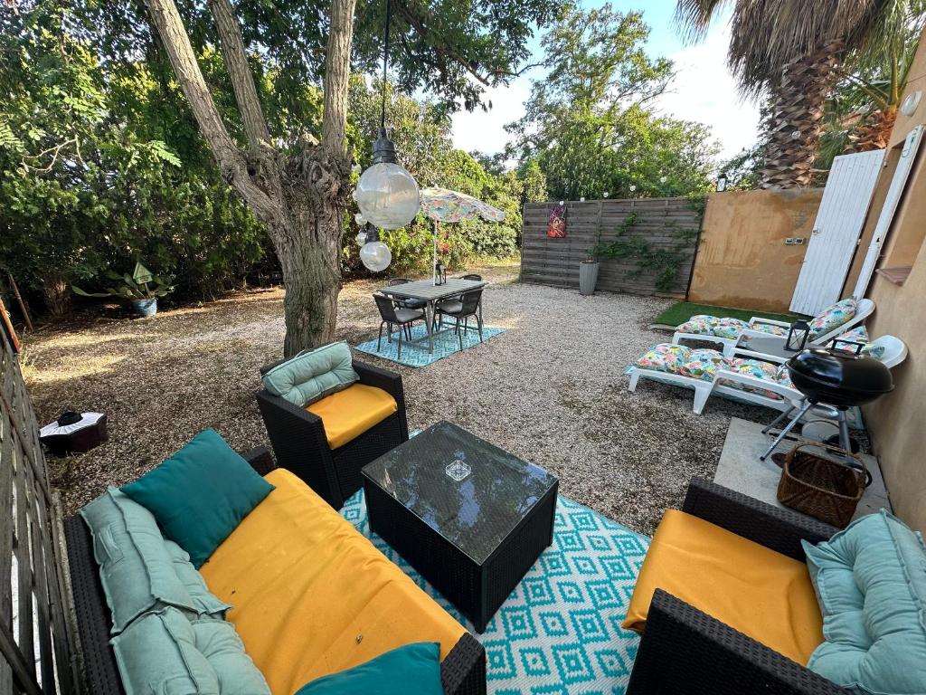 Le mas du bosc في موجيو: حديقة خلفية بها أريكة وكراسي وطاولة