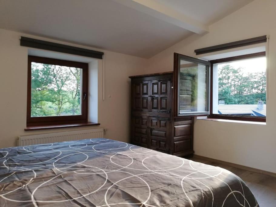 ein Schlafzimmer mit einem großen Bett und zwei Fenstern in der Unterkunft Au Vieux Gouvy in Gouvy