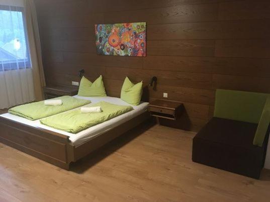 ein Schlafzimmer mit einem Bett und einem Stuhl in der Unterkunft Aineterhof in Ainet