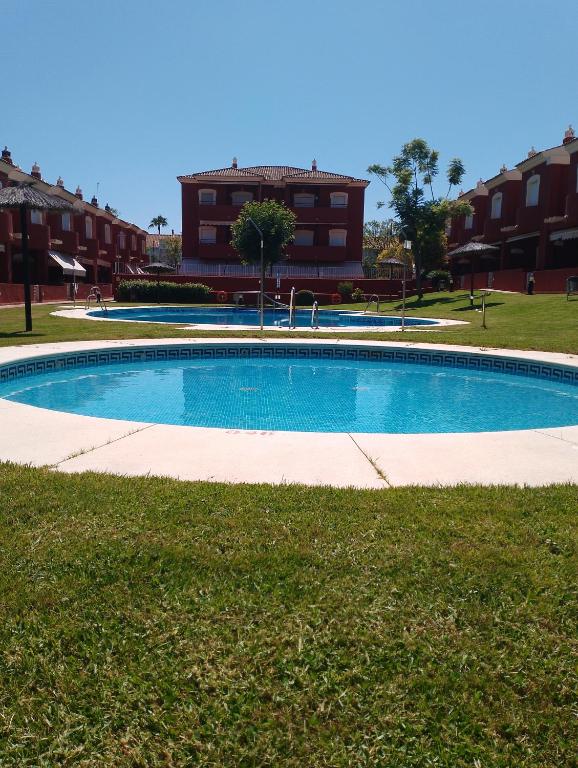 a swimming pool in front of a building at Apartamento Islantilla Club in Islantilla