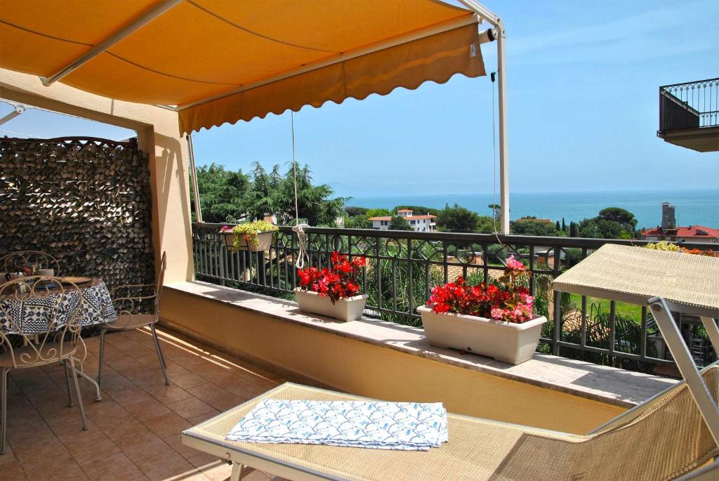 un balcón con 3 macetas de flores sobre una barandilla en CASA DINKY Attico con terrazza vista mare, en Formia