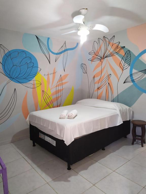 um quarto com um mural de flores na parede em Jambudvipa Hostel em Natal