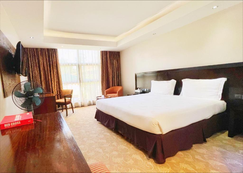 Boma Inn Eldoret في إلدوريت: غرفه فندقيه سرير كبير وتلفزيون