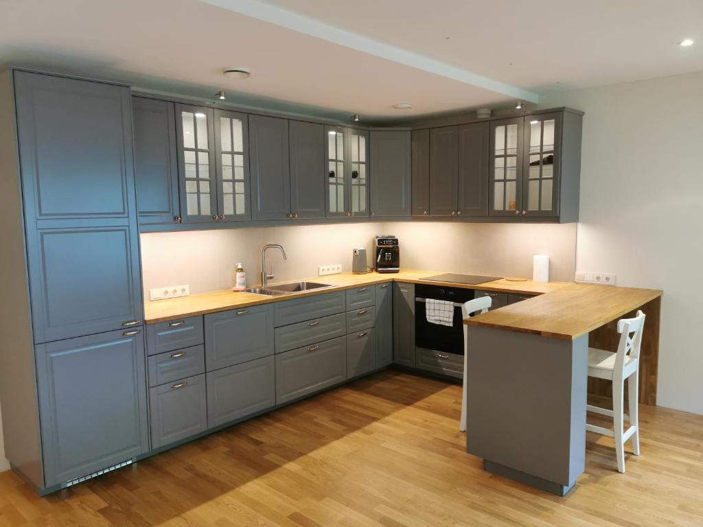 a kitchen with gray cabinets and a wooden counter top at Vytauto 421 Apartments by JK in Palanga