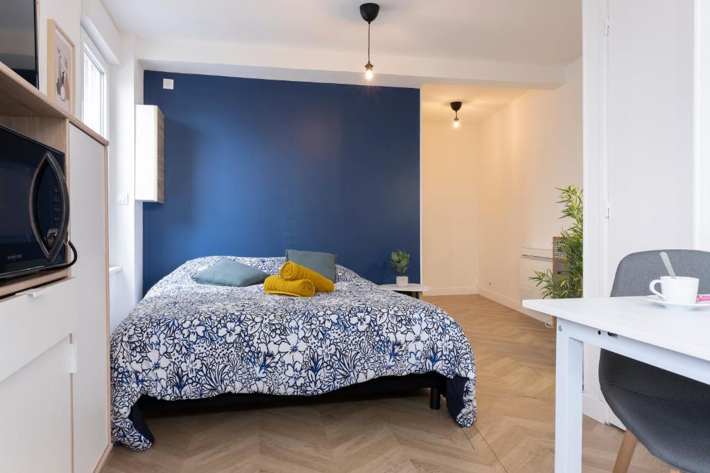 Schlafzimmer mit einem Bett mit blauer Wand in der Unterkunft studio trankil coeur d&#39;Ancenis - balcons d&#39;Ancenis in Ancenis