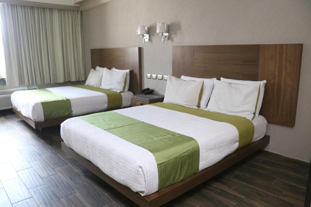 ein Hotelzimmer mit 2 Betten in einem Zimmer in der Unterkunft Hotel Diana del Bosque by DOT Urban in Morelia
