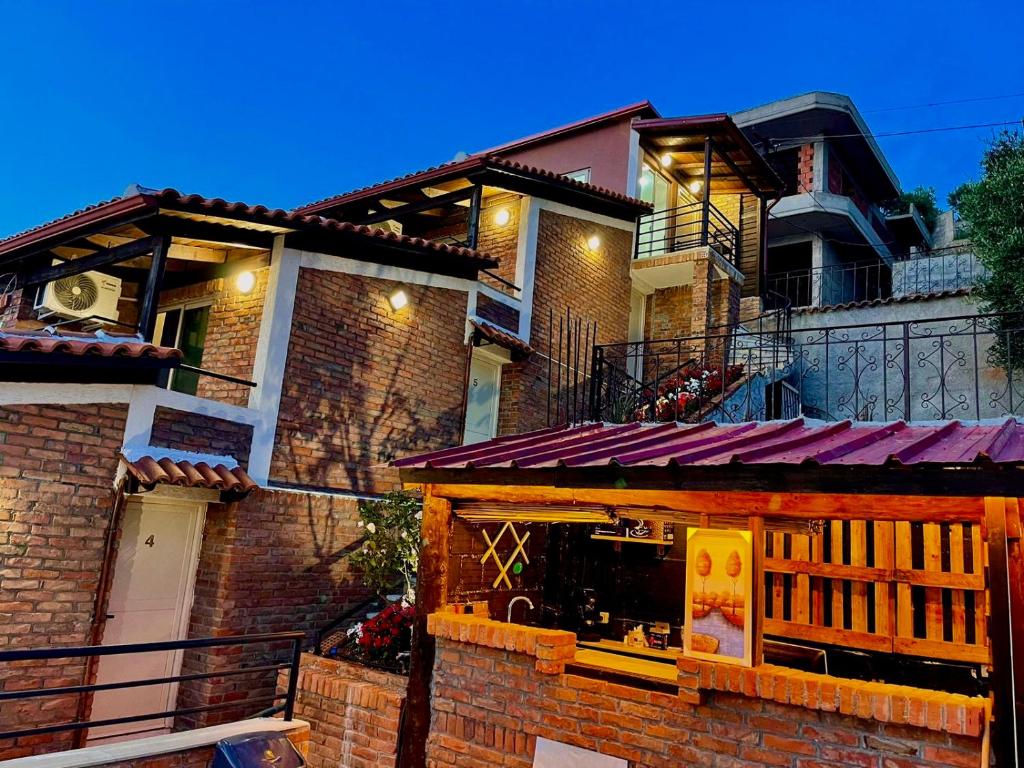 ein Backsteingebäude mit einem Restaurant davor in der Unterkunft Hotel Kappa3 Villas in Vlorë