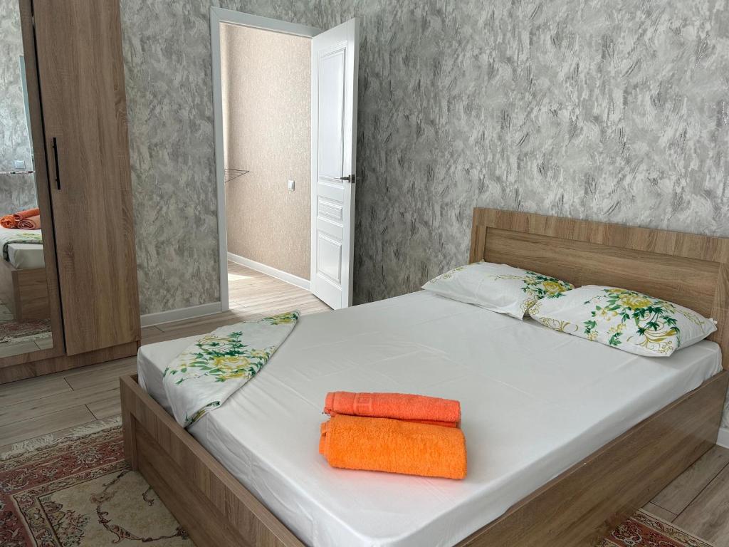 1 dormitorio con 1 cama con 2 toallas en ЖК PRESIDENT в 5 мин от моря en Aktau