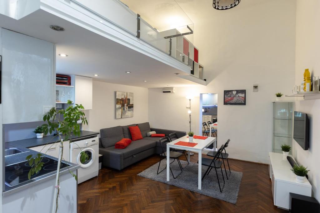 een woonkamer met een bank en een tafel bij Bright & Shine Apartment in Boedapest