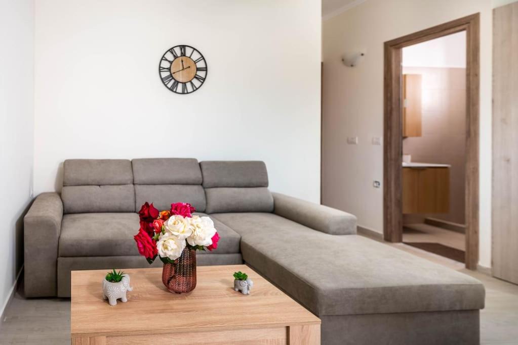 una sala de estar con sofá y un jarrón de flores sobre una mesa en Extreme House en Archangelos
