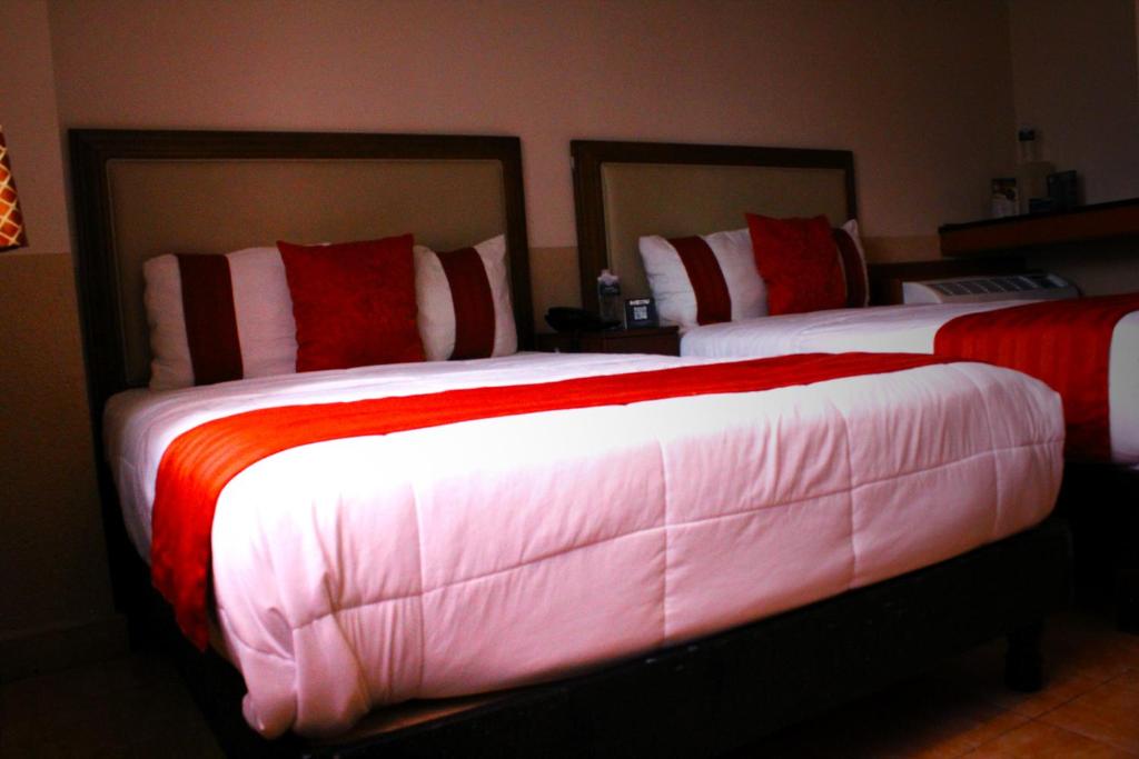 モンテレイにあるEl Regioのベッドルーム1室(ベッド2台、赤と白のシーツ付)
