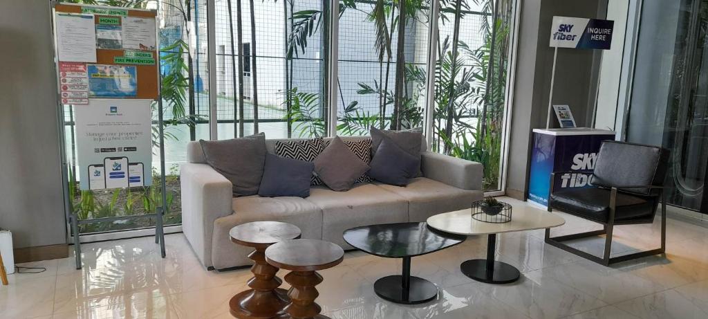 Two Storey Penthouse with Fantastic View في مانيلا: غرفة معيشة مع أريكة وطاولتين