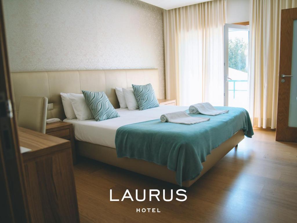 ein Hotelzimmer mit einem Bett mit einer blauen Decke in der Unterkunft Laurus Hotel in Lourinhã