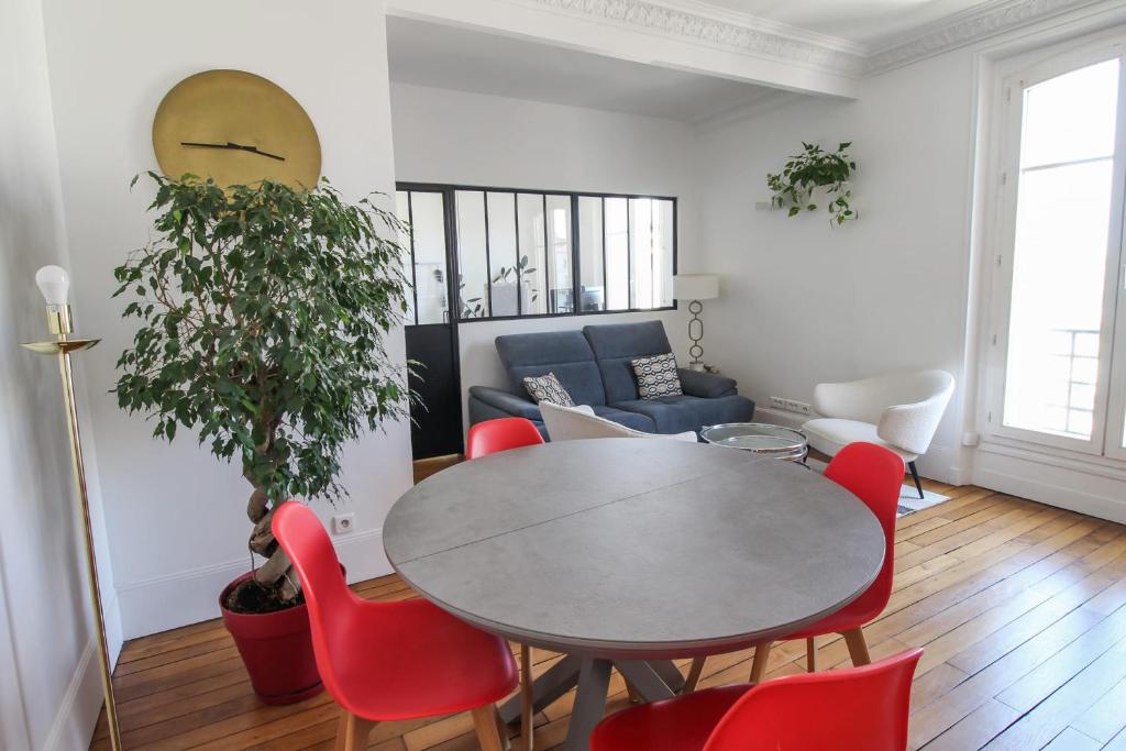 a living room with a table and red chairs at Charming and luminous 2br with balcony - Boulogne-Billancourt - Welkeys in Boulogne-Billancourt