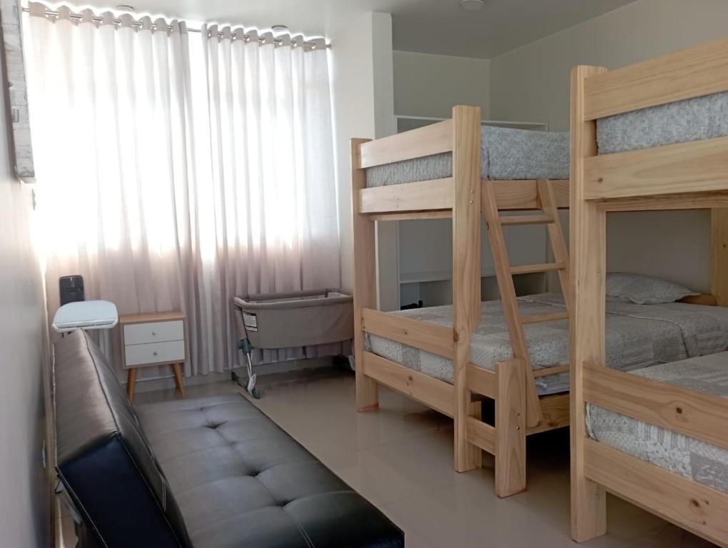 1 dormitorio con 2 literas y sofá en Exclusiva casa de campo en Condominio La Hacienda - Ica en Ica
