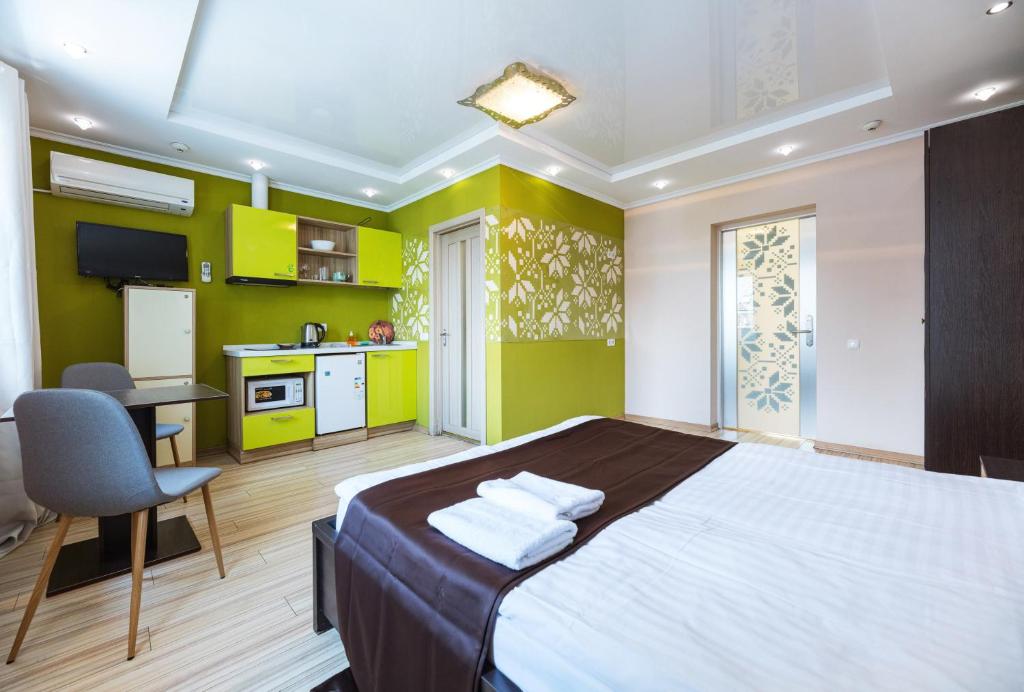 a bedroom with a large bed and a kitchen at Guest house "Golden Gate" in Kyiv