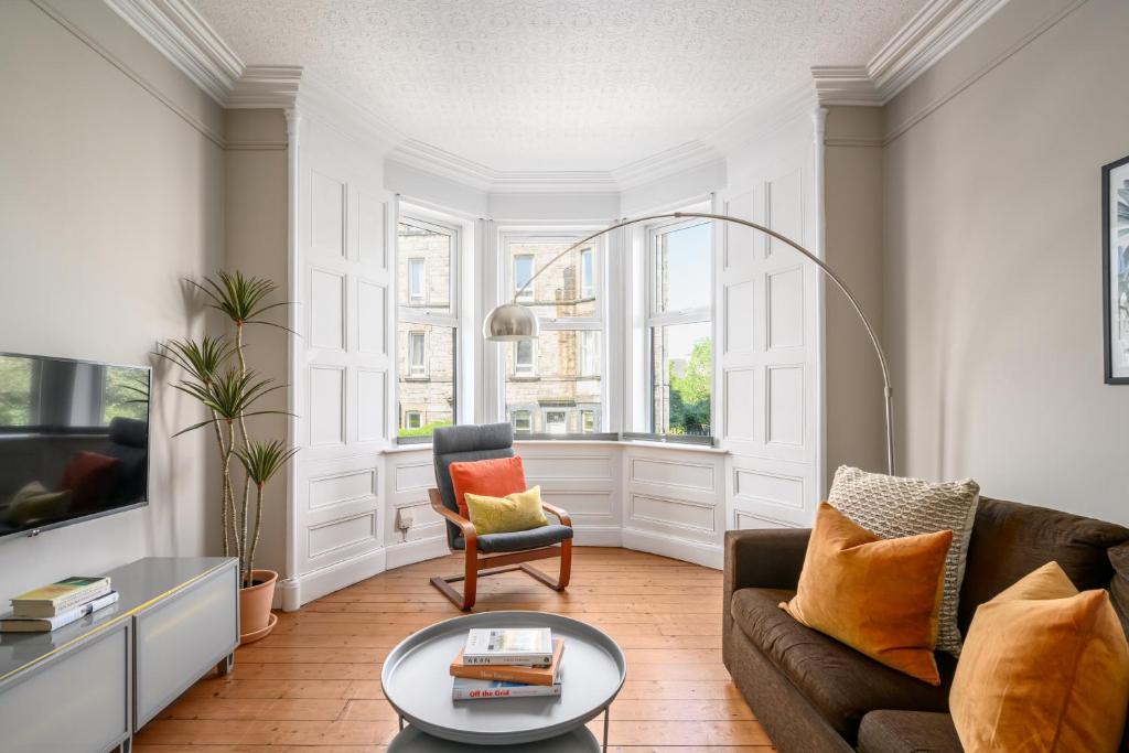 uma sala de estar com um sofá e uma mesa em The Holyrood Park Apartment em Edimburgo