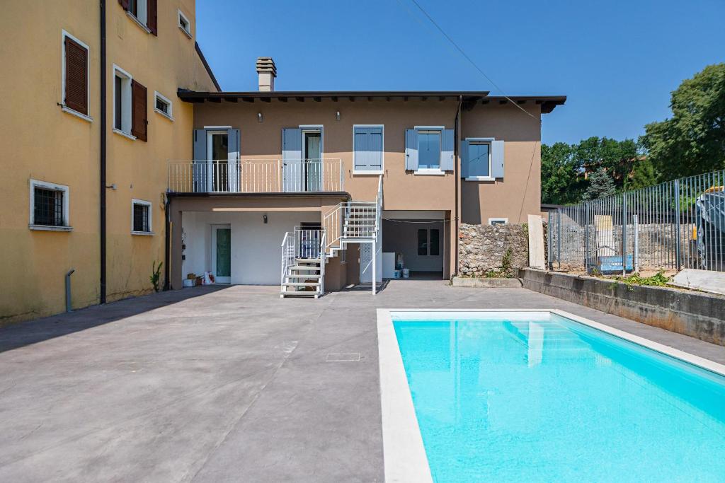 una casa con piscina di fronte a una casa di San Carlo Borromeo Apartments by Wonderful Italy a Soiano del Lago