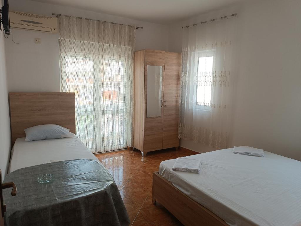 1 dormitorio con 2 camas y 2 ventanas en Accommodation Milla, en Ulcinj