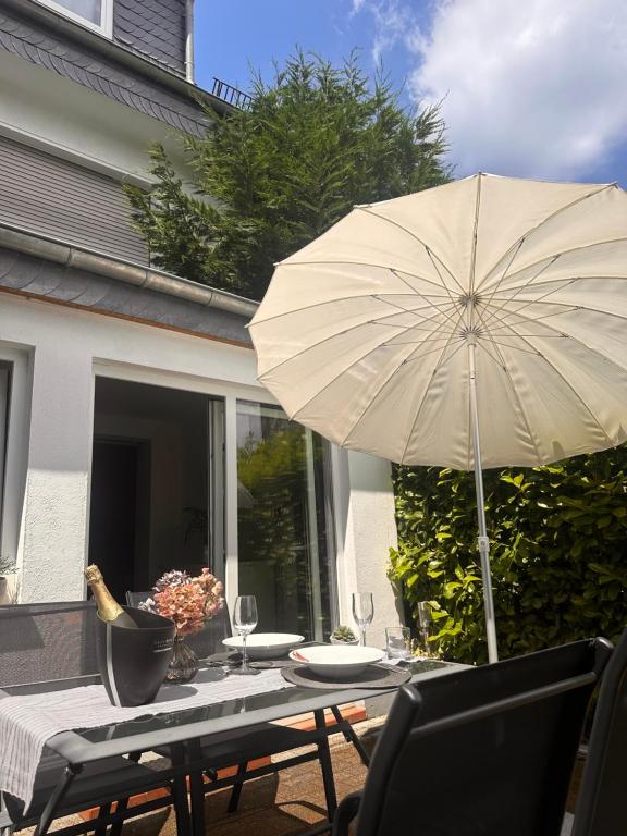 einen Tisch mit einem Sonnenschirm auf einer Terrasse in der Unterkunft Ferienwohnung Wuppertal Ronsdorf Elias Eller in Wuppertal