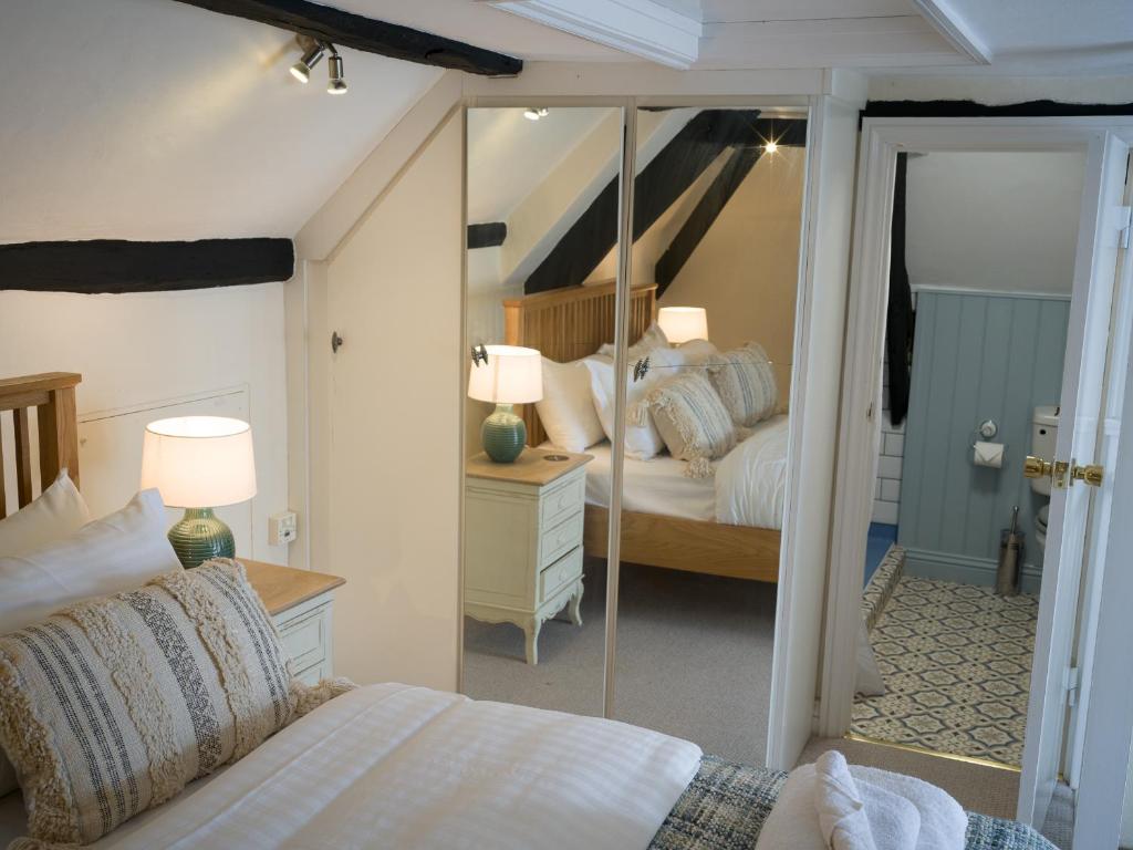 a bedroom with two beds and a large mirror at The Old Thatch Inn in Cheriton Bishop