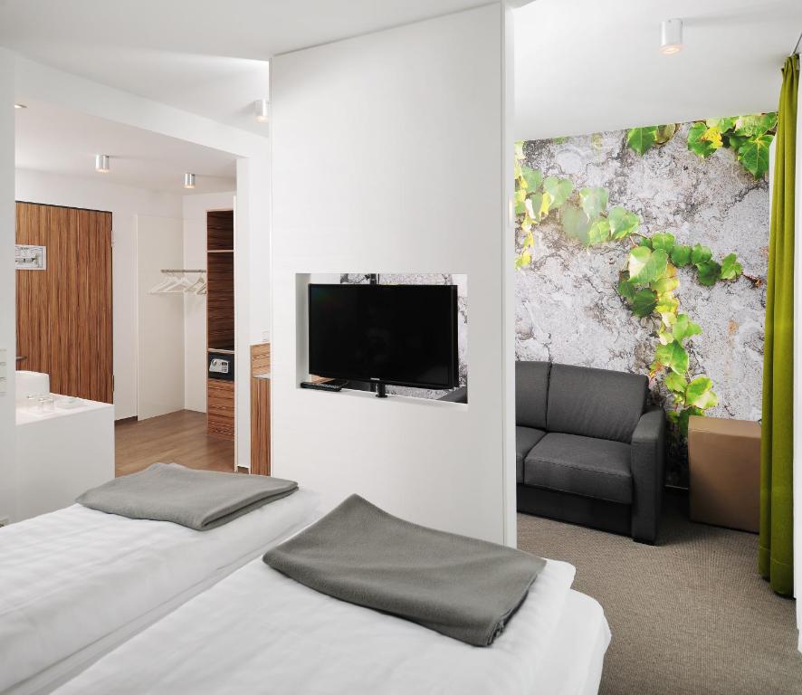 a hotel room with two beds and a flat screen tv at Hotel INNdependence in Mainz