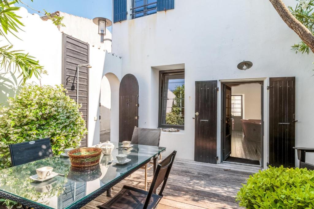 d'une terrasse avec une table et des chaises en verre. dans l'établissement Maison Comoran - Welkeys, à Saint-Pierre-dʼOléron