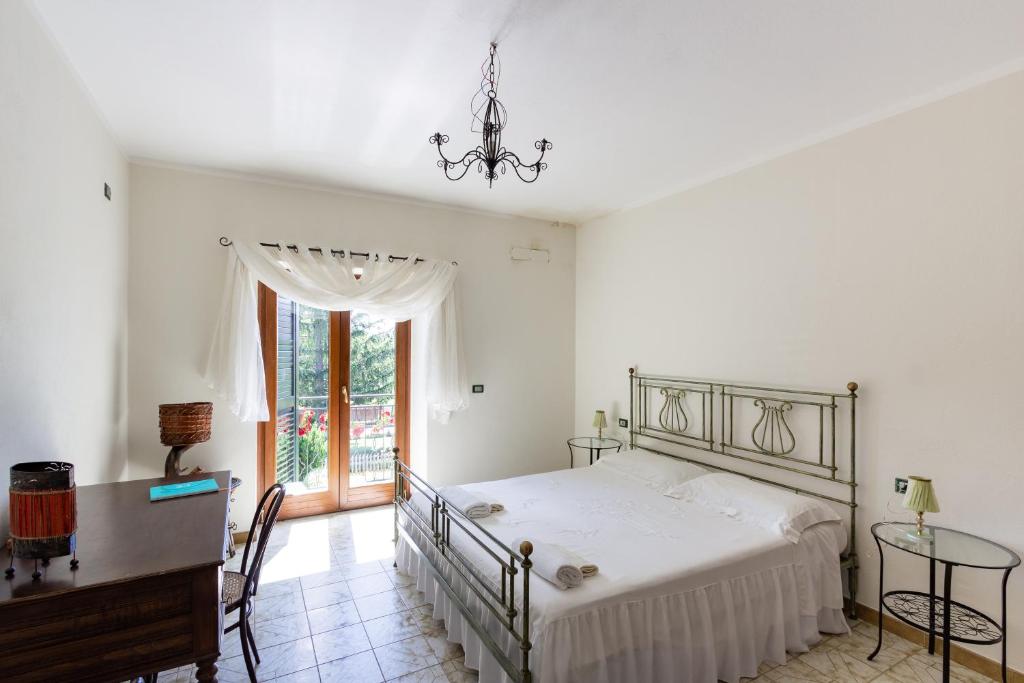 a bedroom with a bed and a table and a window at Casa Fiorella - Irpinia in Lioni