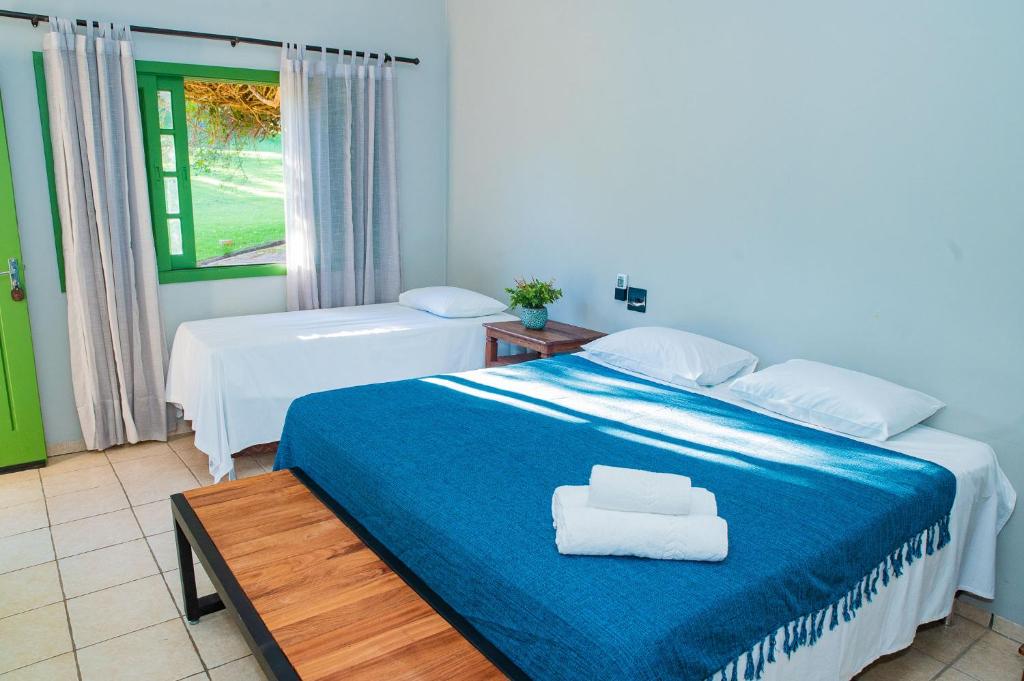 1 dormitorio con 2 camas y ventana en Hotel Fazenda Cachoeiras Serra da Bodoquena, en Bodoquena